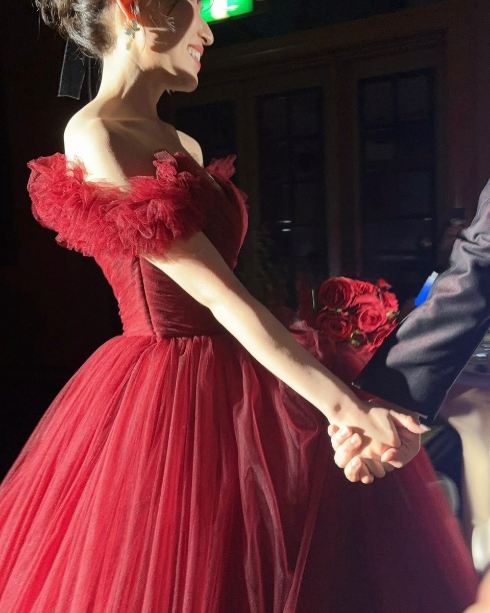 內田真由美換上火紅色晚裝,與丈夫十指緊扣,展露笑容。
