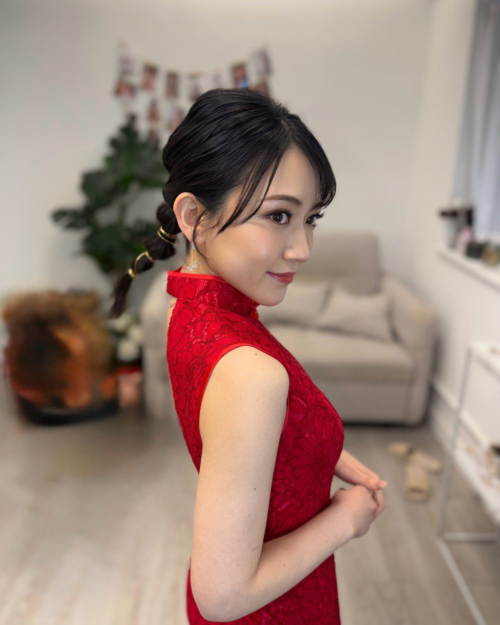 她的妝容精緻,與紅色旗袍打扮相襯。