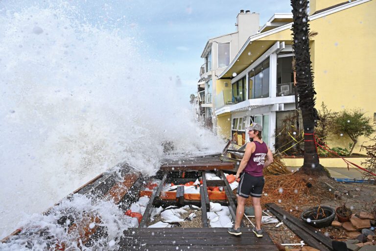 海浪拍打著居民住宅外的人行道。 美聯社