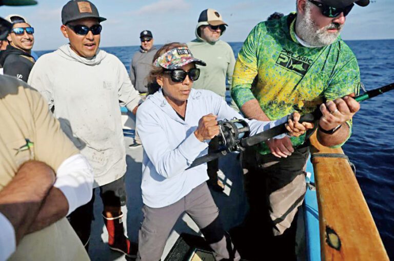 釣客卡連多(Sylvia Caliendo)在甲板水手和釣友幫助下收線釣起一條金槍魚。洛杉磯時報