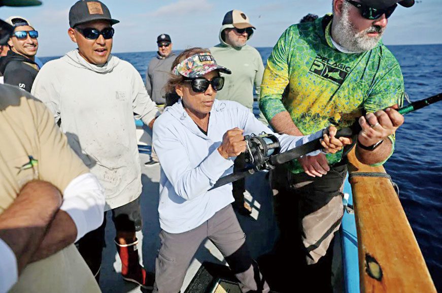 釣客卡連多(Sylvia Caliendo)在甲板水手和釣友幫助下收線釣起一條金槍魚。洛杉磯時報