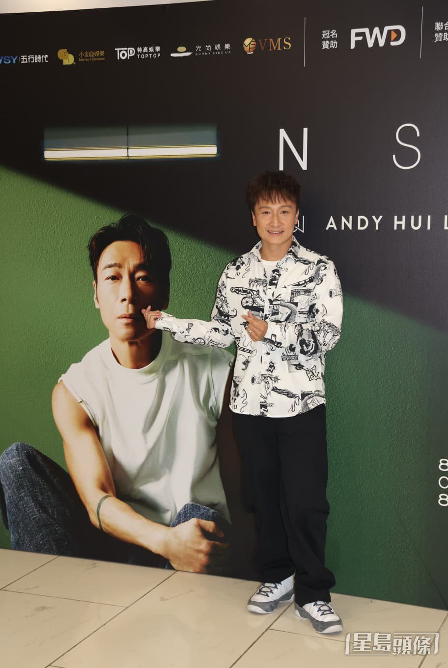 方力申在演唱會佈景板前留影。