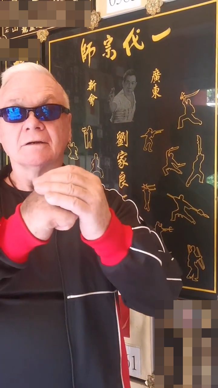 何麥身穿一件印有「劉家洪拳」字樣的外套。