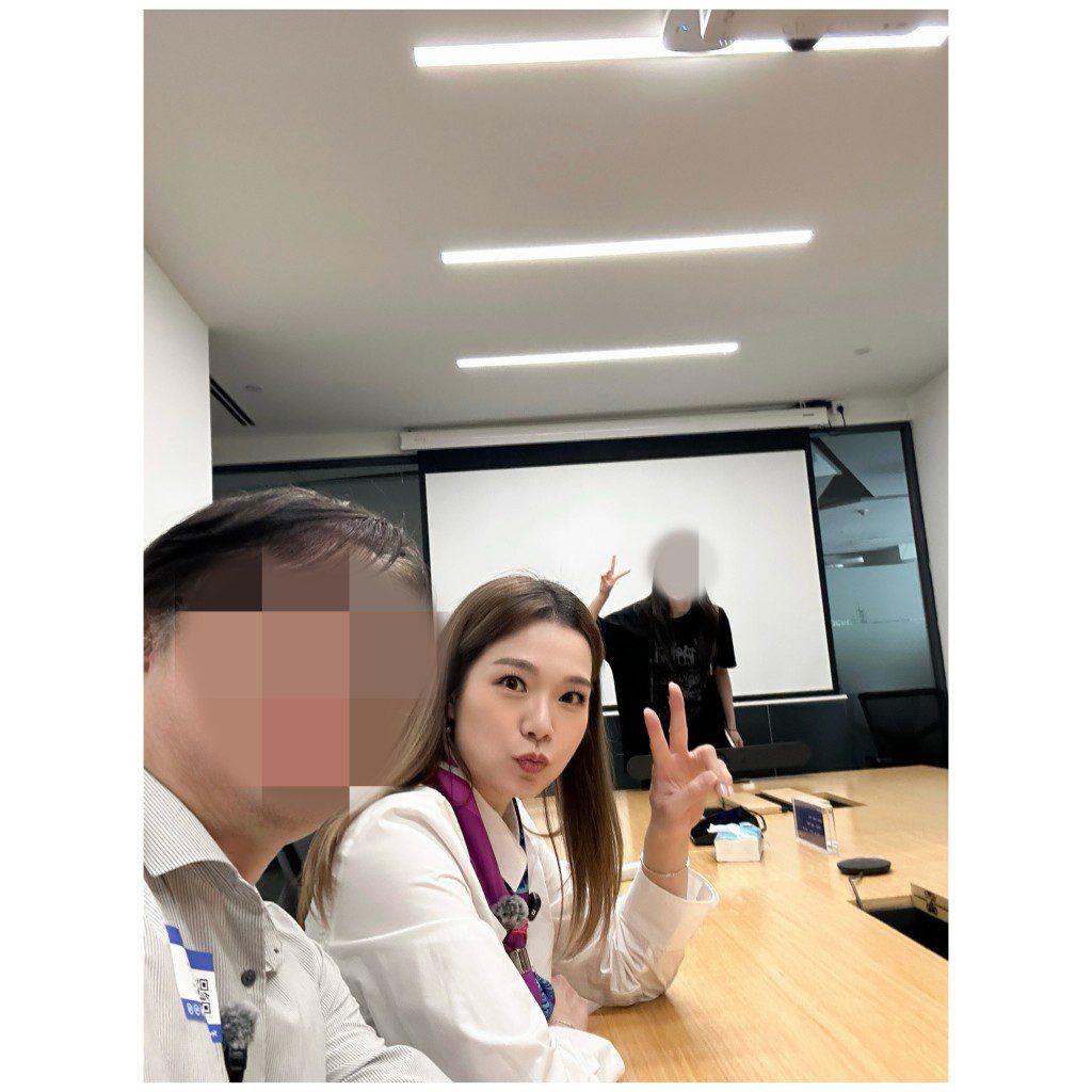 呂慧儀在會議室內與工作夥伴合照並擺出V字手勢,氣氛融洽。