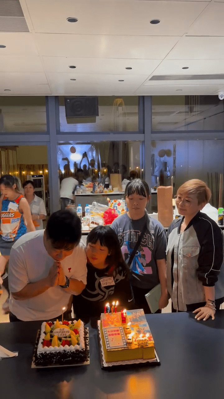 錢嘉樂在兩個生日蛋糕前誠心許願,女兒們乖巧地陪伴在旁。