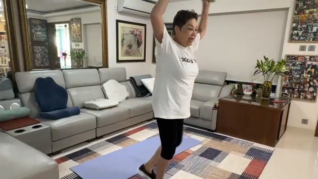 肥媽高舉雙手,認真進行有氧運動。
