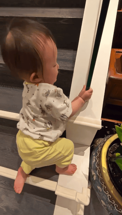 Isla靠著自己的力量扶著欄杆,一步步向上爬。