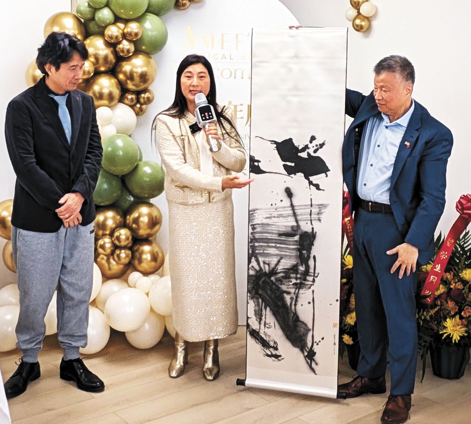 （右起）吳皓、方柳君展示著名書畫家藍老師為慈善音樂會捐贈的畫作。