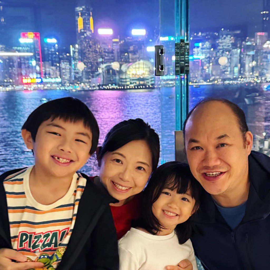 一家四口笑容一致拍攝家庭照。