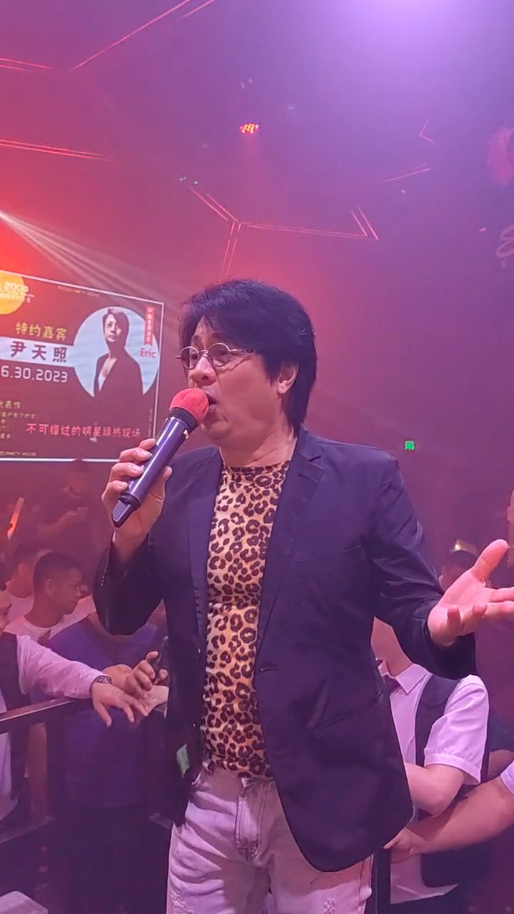 他挺著肚腩唱歌。