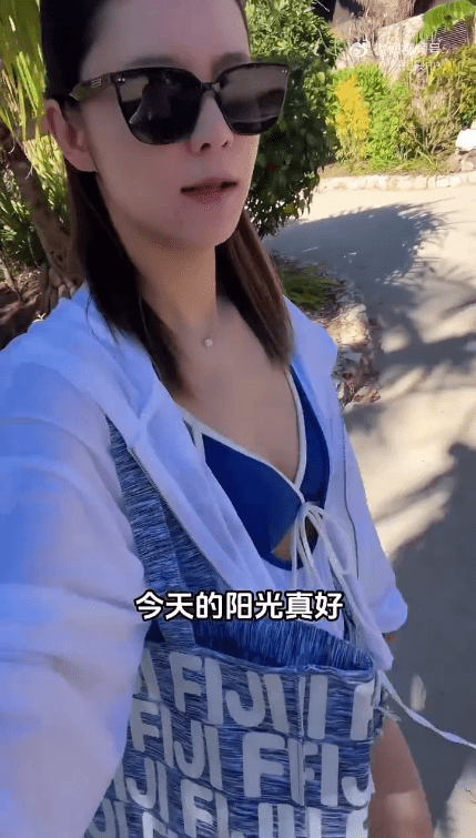 張馨月身穿白色防曬衫搭配泳衣，享受斐濟陽光。