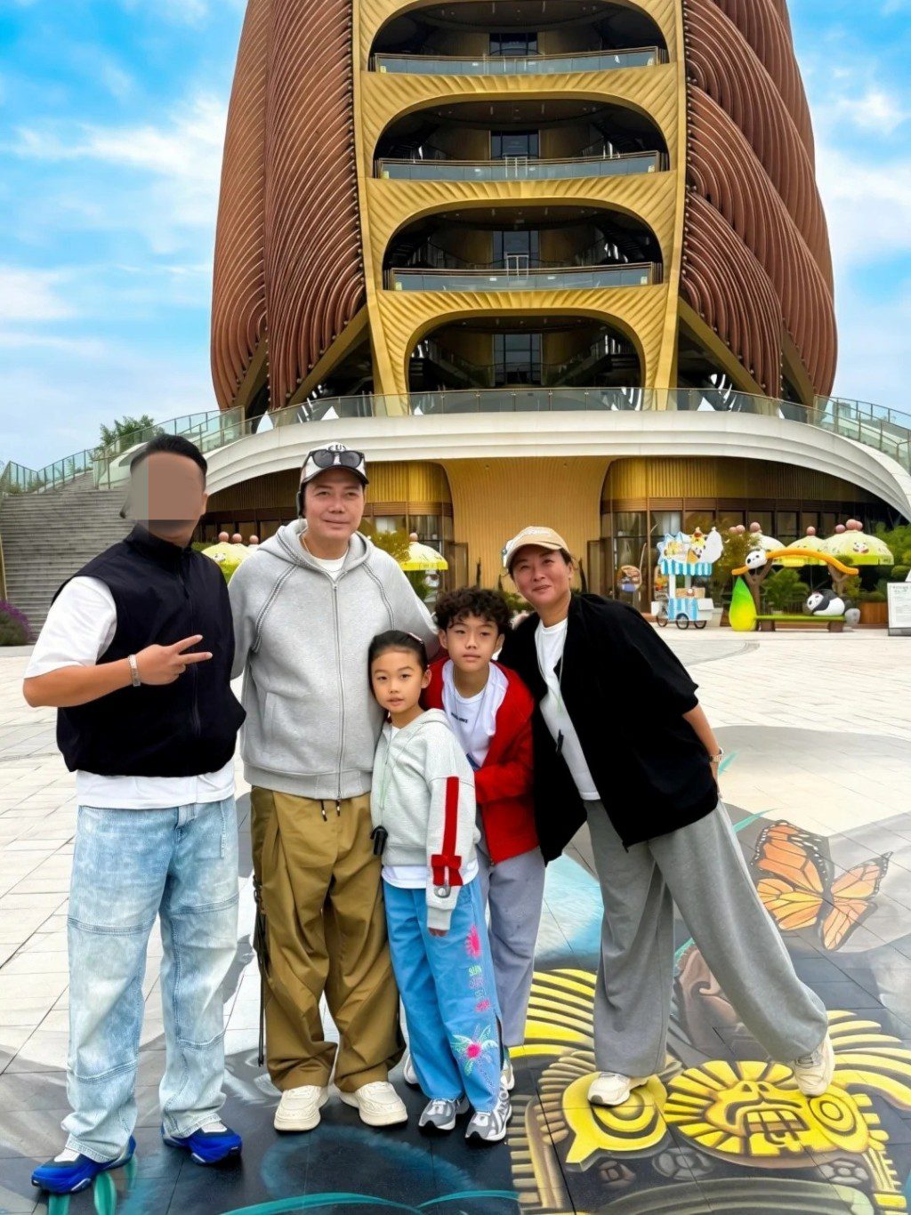 近日謝天華一家四口去旅行,在成都地標建築前同框,一對仔女高度已接近父母。