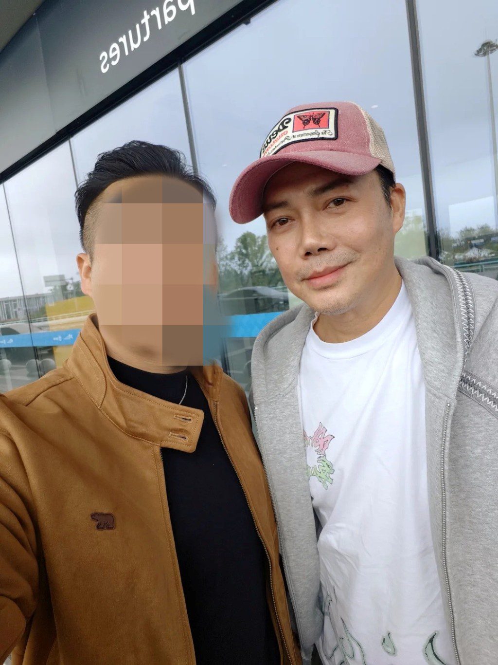謝天華戴粉紅色Cap帽休閒現身,親切地與同行友人貼面合照。
