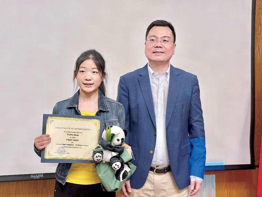王義參贊(右)頒發一等獎予Evelina Xiong。 梁敏育攝