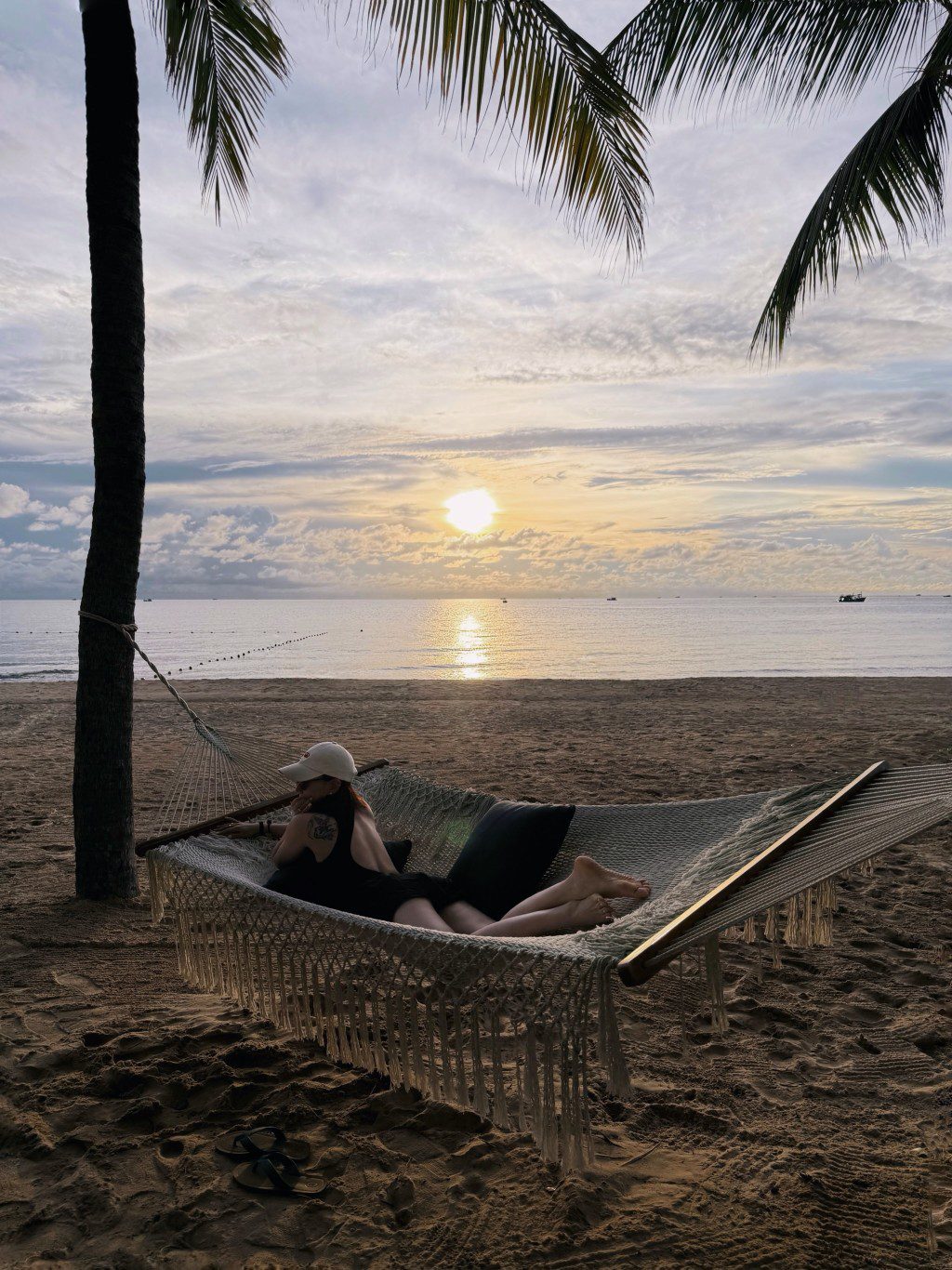 任祉妍在富國島夕陽下的沙灘吊床上閉目休息。