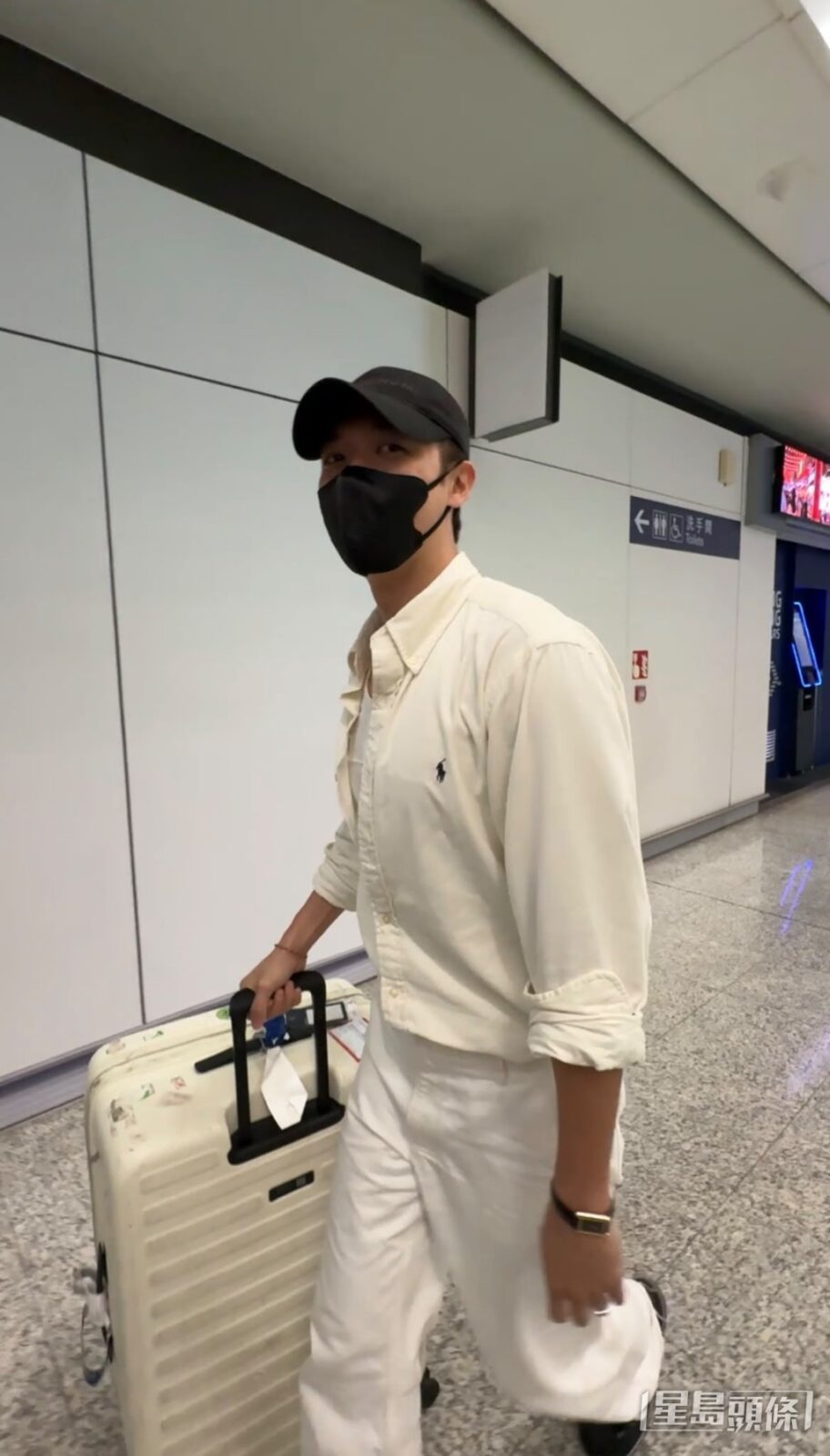 兩人戴著Cap帽和口罩,推著四件行李,在接機大堂B閘現身。