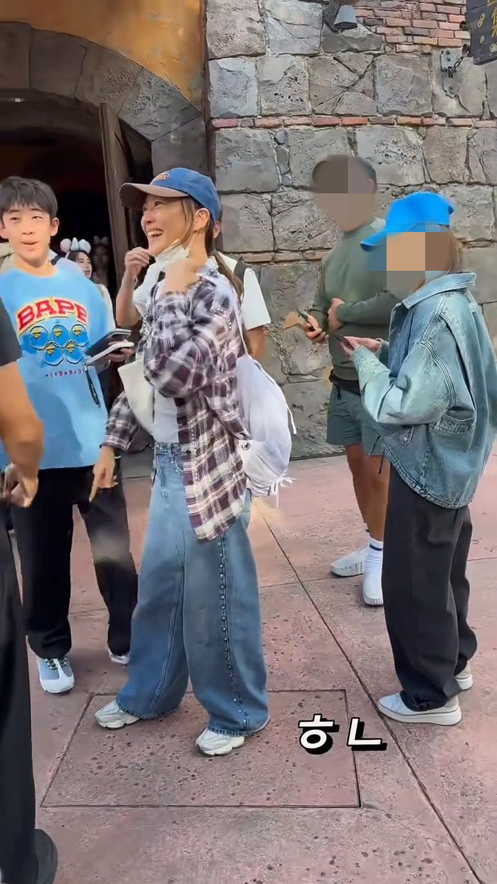 應采兒戴上藍色Cap帽，以格仔襯衫造型現身主題樂園。