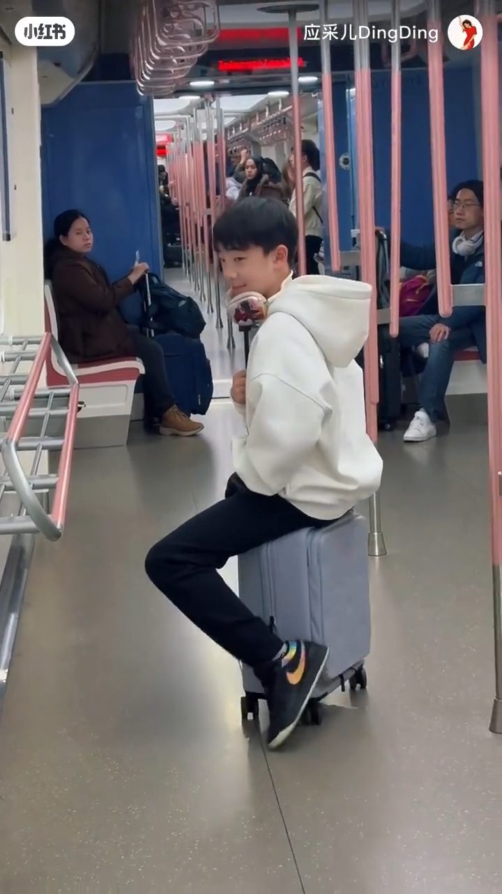 Jasper將行李箱當作滑板車滑行。