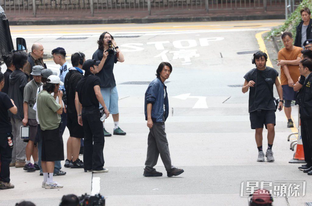 黃子華走到馬路中央準備拍攝。