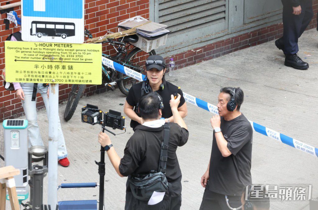 周殷廷在警方封鎖線旁與攝影團隊仔細討論鏡頭角度。