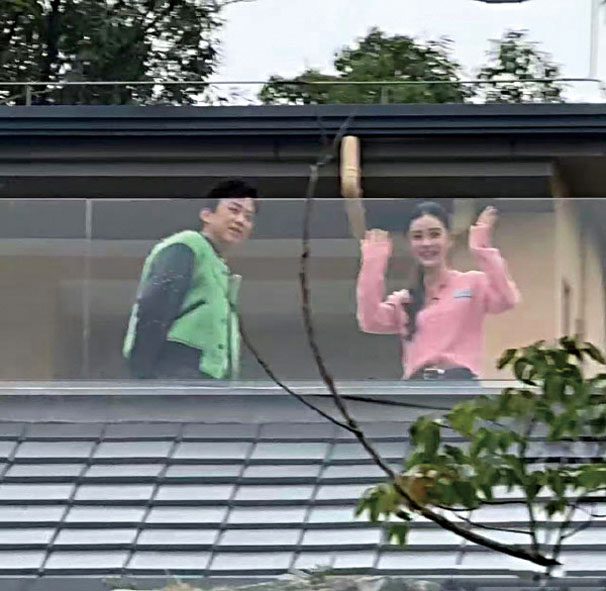 兩人揮手微笑。網上圖片