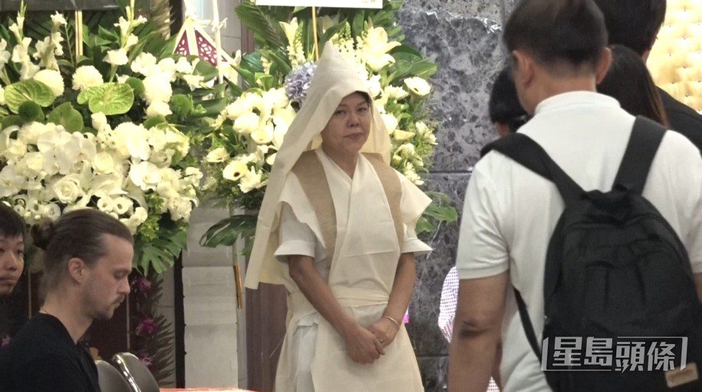 何麥遺孀 Christie 在靈堂內接待前來悼念的親友,神情憔悴。