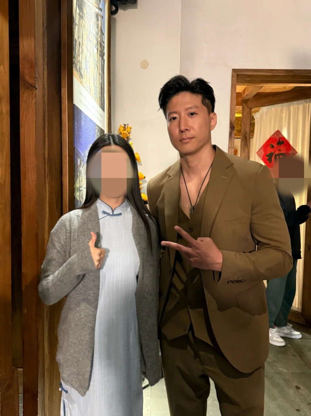 三子洪天照身穿筆挺啡色西裝，與父親合照時擺出V字手勢，樣貌與爸爸極為相似。