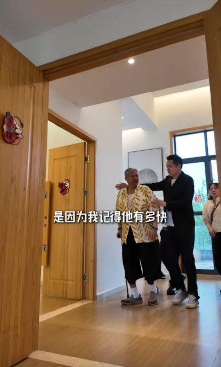 洪金寶需使用柺杖，並要旁人攙扶協助。