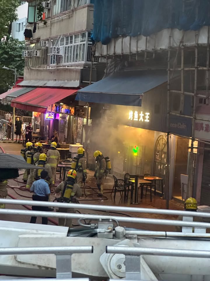多名消防員在「烤魚大王」店外準備,現場煙霧彌漫。